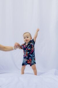 Baby in hawaiian shirt with arm raised